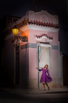 Close up view of a young redhead girl on a retro vintage dress on the urban city.