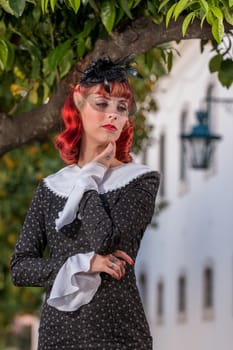 Close up view of a young redhead girl on a retro vintage dress on the urban city.