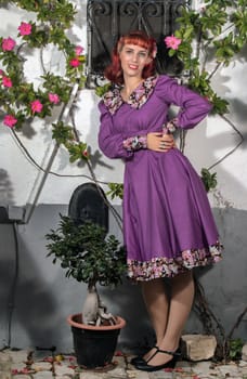 Close up view of a young redhead girl on a retro vintage dress on the urban city.