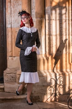 Close up view of a young redhead girl on a retro vintage dress on the urban city.