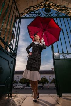 Close up view of a young redhead girl on a retro vintage dress on the urban city.