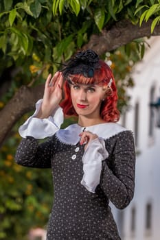 Close up view of a young redhead girl on a retro vintage dress on the urban city.