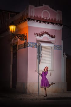 Close up view of a young redhead girl on a retro vintage dress on the urban city.