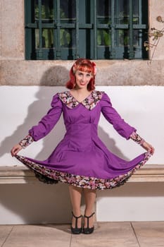 Close up view of a young redhead girl on a retro vintage dress on the urban city.