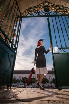 Close up view of a young redhead girl on a retro vintage dress on the urban city.