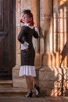 Close up view of a young redhead girl on a retro vintage dress on the urban city.