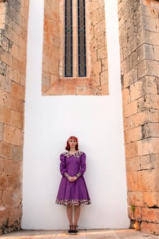 Close up view of a young redhead girl on a retro vintage dress on the urban city.