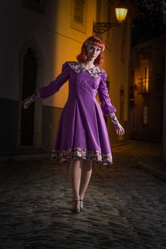 Close up view of a young redhead girl on a retro vintage dress on the urban city.