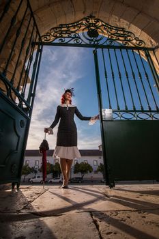 Close up view of a young redhead girl on a retro vintage dress on the urban city.