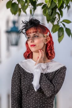 Close up view of a young redhead girl on a retro vintage dress on the urban city.