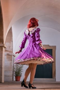 Close up view of a young redhead girl on a retro vintage dress on the urban city.