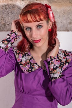 Close up view of a young redhead girl on a retro vintage dress on the urban city.