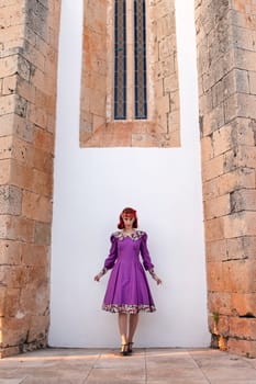 Close up view of a young redhead girl on a retro vintage dress on the urban city.