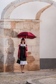 Close up view of a young redhead girl on a retro vintage dress on the urban city.