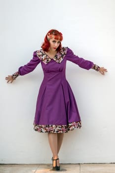 Close up view of a young redhead girl on a retro vintage dress on the urban city.