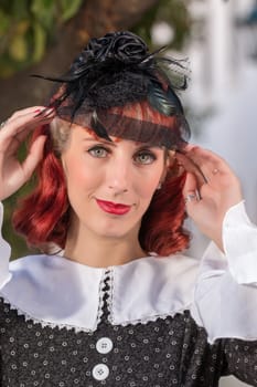 Close up view of a young redhead girl on a retro vintage dress on the urban city.