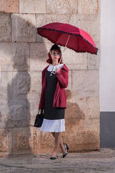 Close up view of a young redhead girl on a retro vintage dress on the urban city.