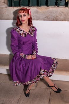 Close up view of a young redhead girl on a retro vintage dress on the urban city.