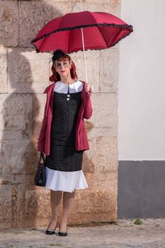 Close up view of a young redhead girl on a retro vintage dress on the urban city.