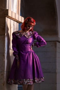 Close up view of a young redhead girl on a retro vintage dress on the urban city.