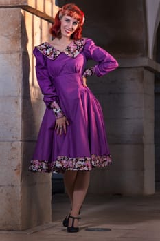 Close up view of a young redhead girl on a retro vintage dress on the urban city.