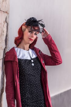 Close up view of a young redhead girl on a retro vintage dress on the urban city.