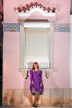 Close up view of a young redhead girl on a retro vintage dress on the urban city.