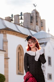 Close up view of a young redhead girl on a retro vintage dress on the urban city.