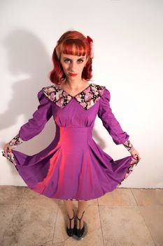 Close up view of a young redhead girl on a retro vintage dress on the urban city.