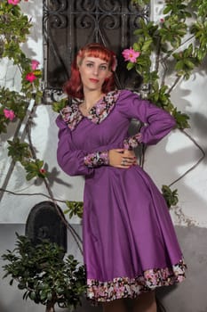 Close up view of a young redhead girl on a retro vintage dress on the urban city.