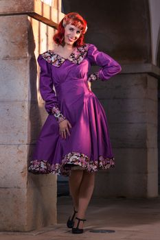 Close up view of a young redhead girl on a retro vintage dress on the urban city.