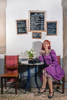 Close up view of a young redhead girl on a retro vintage dress on the urban city.