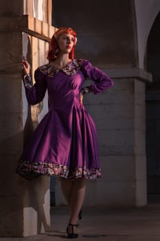 Close up view of a young redhead girl on a retro vintage dress on the urban city.