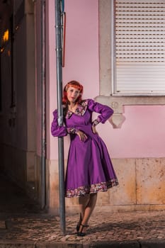 Close up view of a young redhead girl on a retro vintage dress on the urban city.