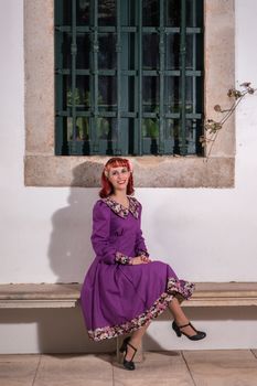 Close up view of a young redhead girl on a retro vintage dress on the urban city.