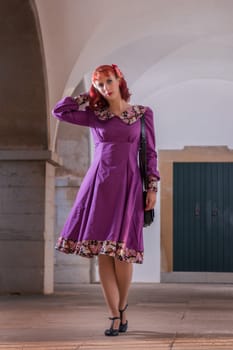 Close up view of a young redhead girl on a retro vintage dress on the urban city.