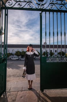 Close up view of a young redhead girl on a retro vintage dress on the urban city.