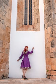 Close up view of a young redhead girl on a retro vintage dress on the urban city.