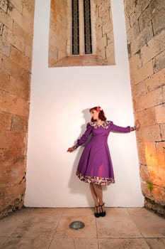 Close up view of a young redhead girl on a retro vintage dress on the urban city.