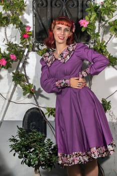 Close up view of a young redhead girl on a retro vintage dress on the urban city.