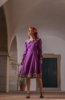 Close up view of a young redhead girl on a retro vintage dress on the urban city.