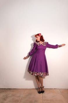 Close up view of a young redhead girl on a retro vintage dress on the urban city.