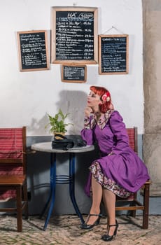 Close up view of a young redhead girl on a retro vintage dress on the urban city.