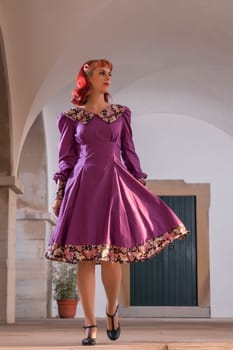 Close up view of a young redhead girl on a retro vintage dress on the urban city.