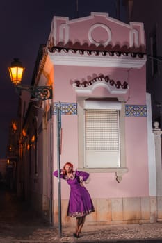 Close up view of a young redhead girl on a retro vintage dress on the urban city.