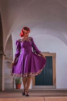 Close up view of a young redhead girl on a retro vintage dress on the urban city.