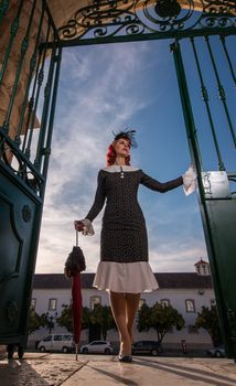 Close up view of a young redhead girl on a retro vintage dress on the urban city.