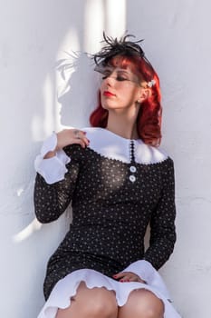 Close up view of a young redhead girl on a retro vintage dress on the urban city.