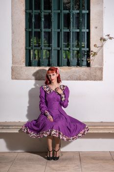 Close up view of a young redhead girl on a retro vintage dress on the urban city.