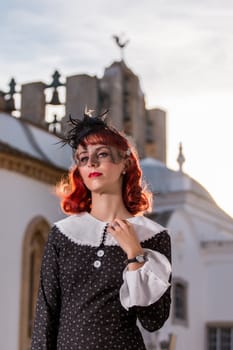 Close up view of a young redhead girl on a retro vintage dress on the urban city.